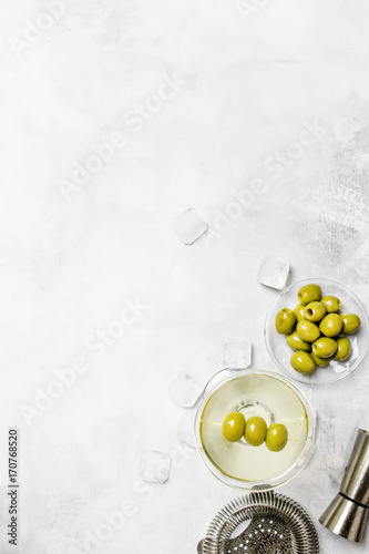 Dry vermouth cocktail with green olives, gray background, top view photo