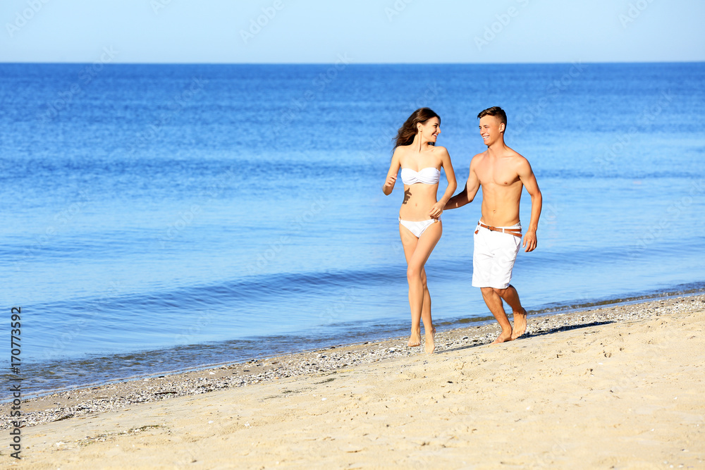 Happy young couple on sea beach at resort