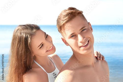 Happy young couple on sea beach at resort © Africa Studio