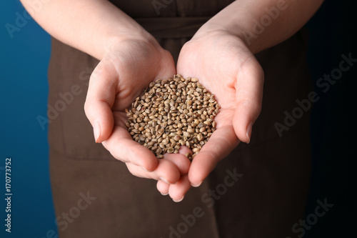 Young woman holding hemp seeds in hands, closeup