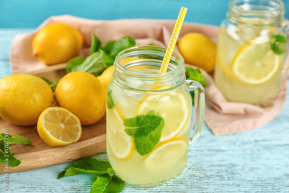 Fototapeta premium Jar of lemon juice and fresh lemons on table