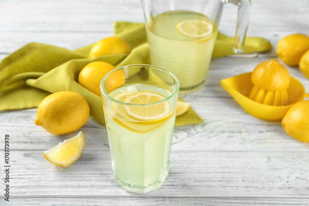 Fototapeta premium Composition with glass of lemon juice and fresh lemons on table