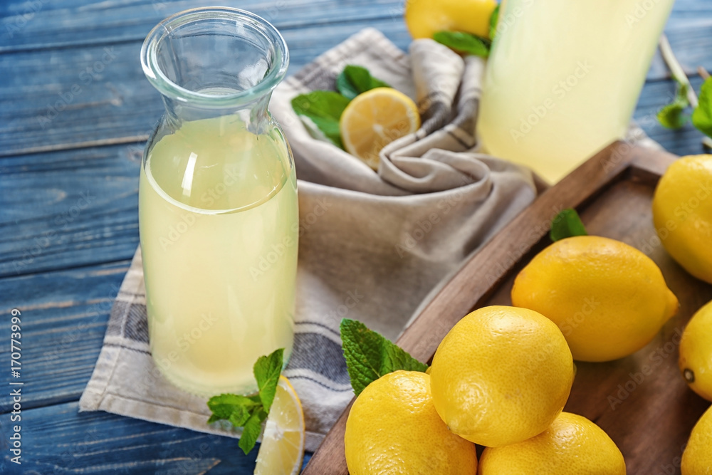 Composition with bottle of lemon juice and fresh lemons on table Composition with bottle of lemon juice and fresh lemons on table