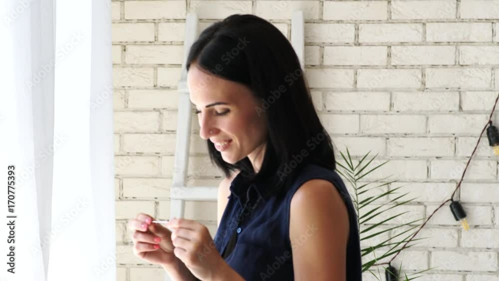 Picture of happy young woman looking at positive pregnancy test.