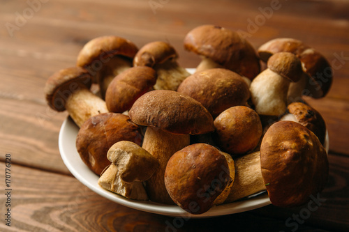 Plate with Porcini Mushrooms on wooden background