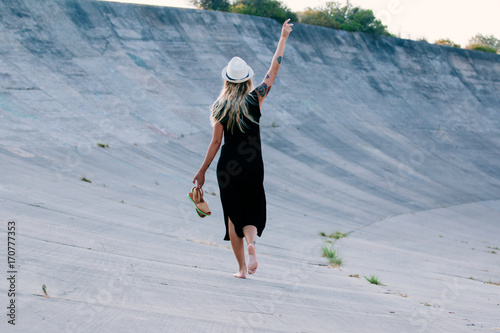 Woman with a black dress walking her back to the camera