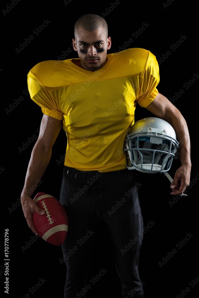 Stockfoto American football player holding a ball and head gear | Adobe  Stock
