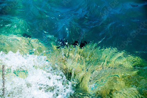 Fototapeta Naklejka Na Ścianę i Meble -   turquoise sea water crashing on calcium white stones against the azure sky on a sunny day