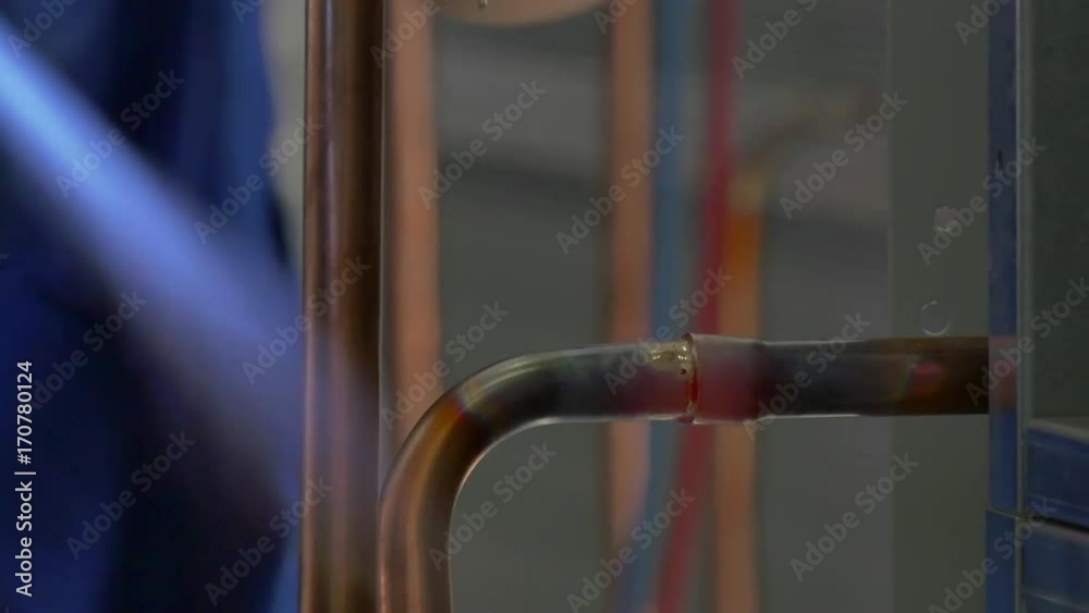 Hands of a worker welding of metal welding in factory. Industria. Automation of work. Manufacture of refrigeration and ventilation industrial equipment and air conditioners. Modern technologies. Hands of a worker welding of metal welding in factory. Industria. Automation of work. Manufacture of refrigeration and ventilation industrial equipment and air conditioners. Modern technologies.