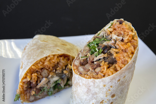 Two halves of a carne asada burrito on a plate photo