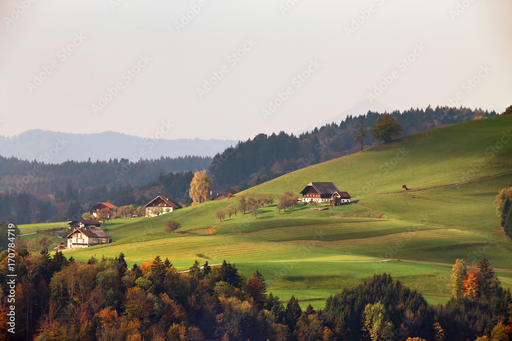 view of Austrian village on mountain hills in Alps. Beautiful mountain rural autumn landscape.