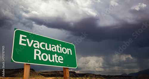 Foto Evacuation Route Green Road Sign and Stormy Clouds