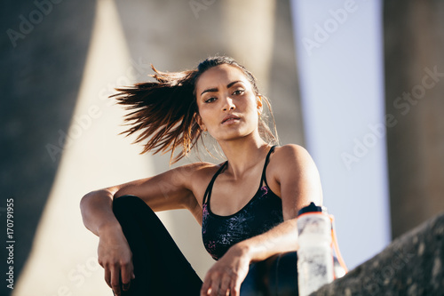 Fit woman sitting outdoors after workout session