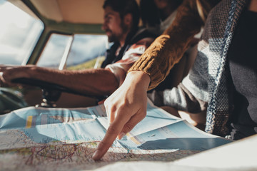 Friends on road trip using map for directions