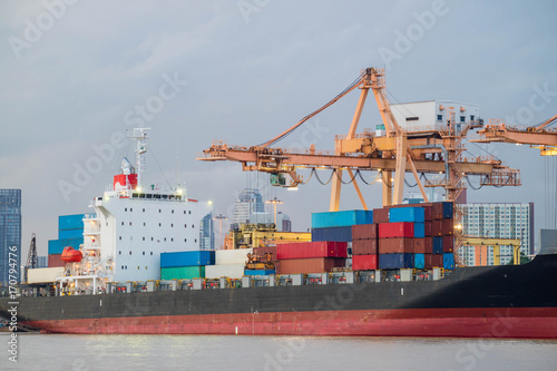 Shipping trade port. Container cargo ship loading or unloading by crane bridge. Logistics industrial and transportation business background