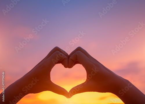 Silhouette the woman hands to be heart shape on sunset background. Happy, Love, Valentine's day idea, sign, symbol, concept.