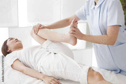 A female massager makes a thigh massage