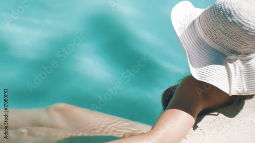 Woman with wide brimmed hat at the pool