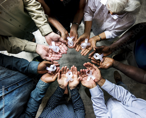 Aerial view of white ribbons on people palms for bone cancer awareness and antiviolence photo