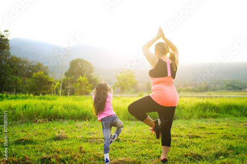 fat woman exercise with daugther in nature outdoor