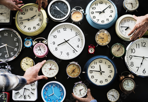 Closeup of hands holding clocks