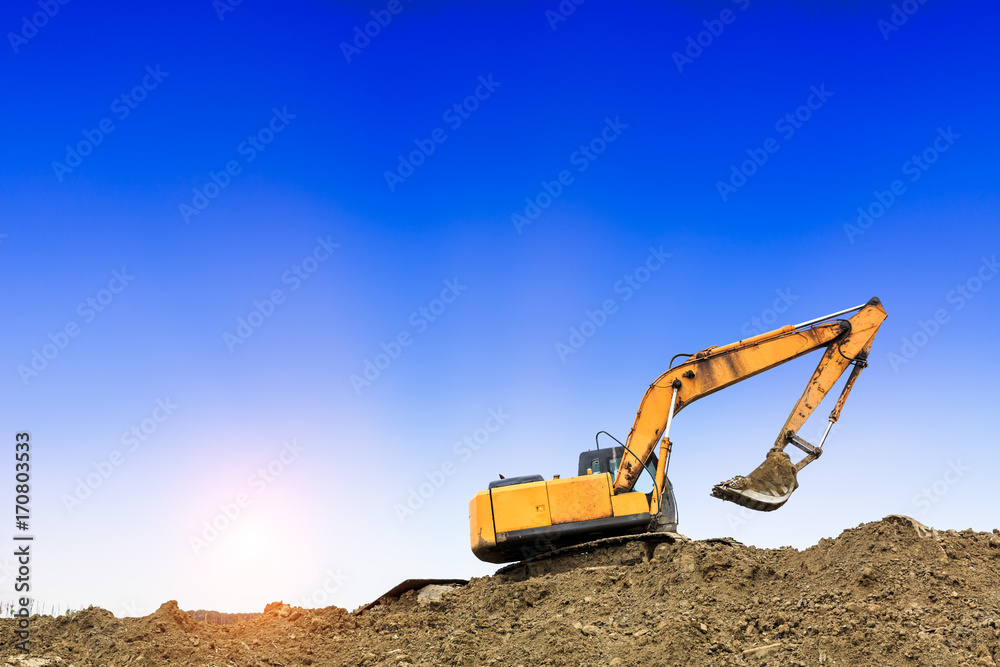 Excavator working at construction site on sunset Excavator working at construction site on sunset