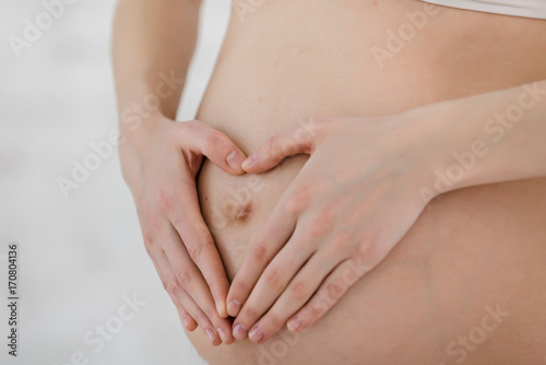 Heart shaped fingers on pregnant tummy