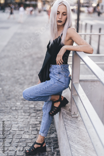 Young cool woman in the city at sunset photo