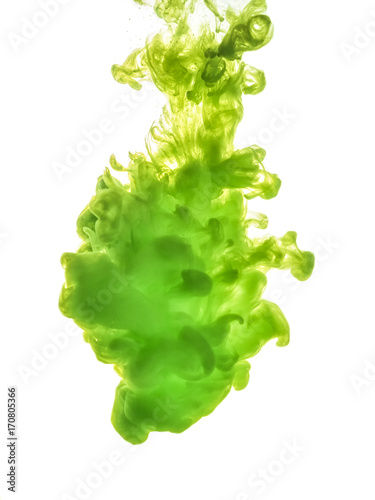 Ink swirl in water isolated on white background. The paint in the water. Soft dissemination a droplets of green ink in water close-up. Abstract background. Soft focus.