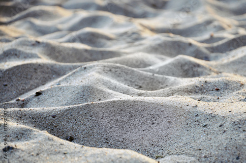 Texture of waves of gray sand. Selective focus.