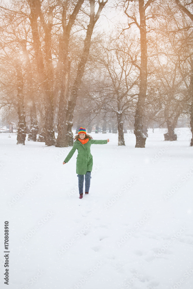 Happy young woman enjoys the snow in nature, park. Winter. concept
