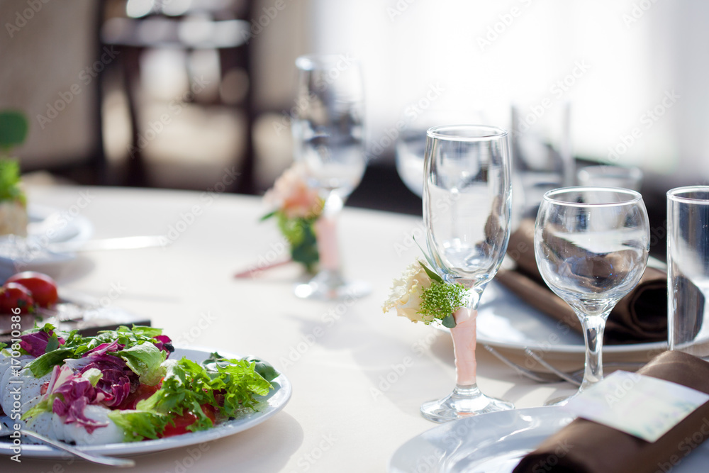 Table setting in the restaurant. floral decor on the glasses, wedding Table setting in the restaurant. floral decor on the glasses, wedding