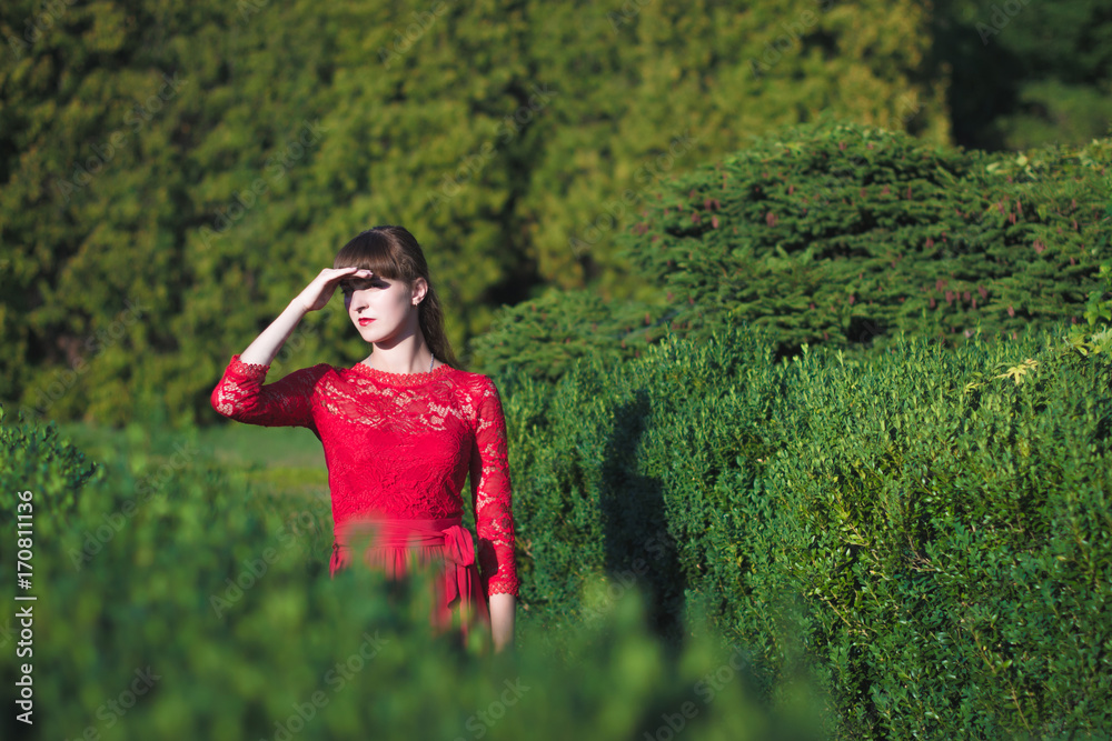 Beautiful young girl in a long red dress in an autumn park. Beautiful young girl in a long red dress in an autumn park.