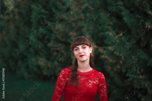Portrait of a beautiful young girl in a red dress. photo