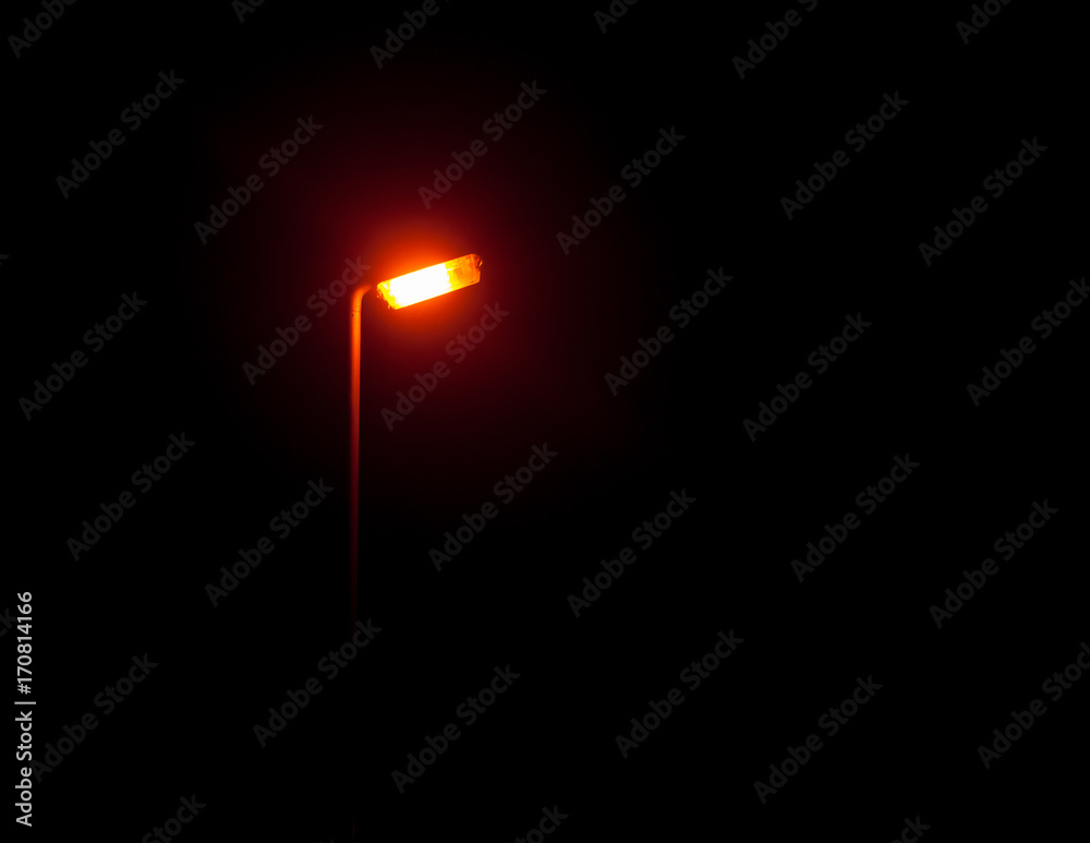 A bright glowing street lamp light in the dark outside at night