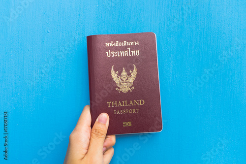 Left hand holding Thailand passport