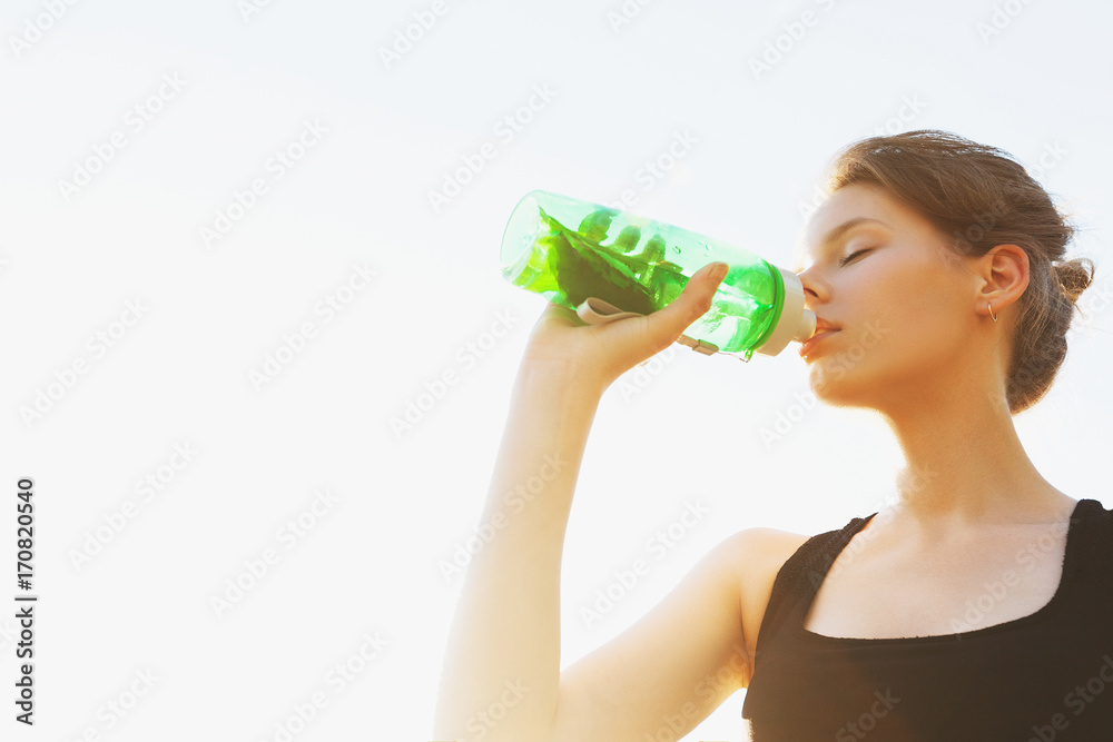 Beautiful young girl is drinking water on sports training Beautiful young girl is drinking water on sports training