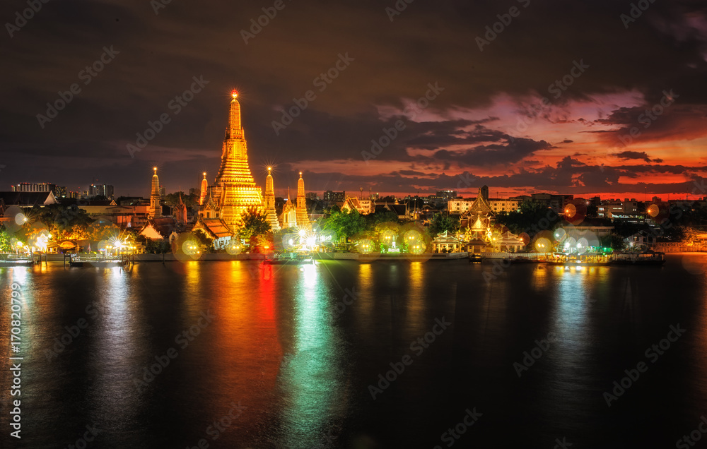 Wat Arun,the temple of dawn. famous landmark temple on Chaopraya River. Dramatic sunset twilight with bokeh lights at Bangkok,Thailand