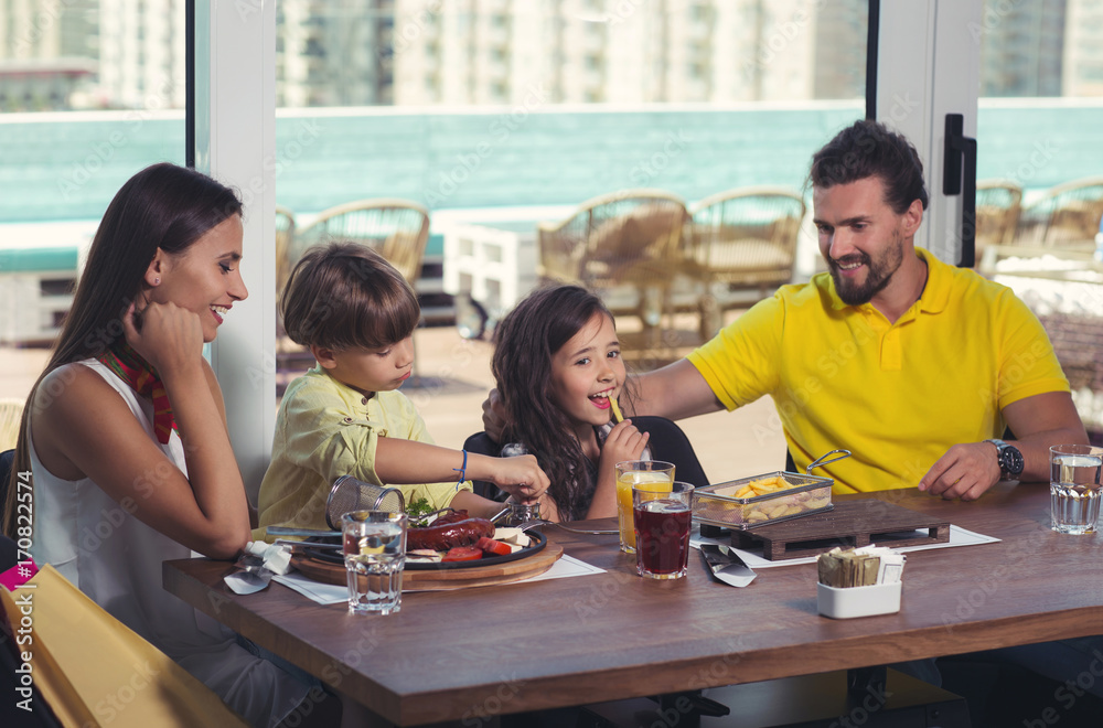 A four-member family having great time in a restaurant A four-member family having great time in a restaurant