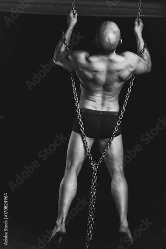 bodybuilder with chains on black background