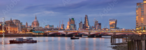 Illuminated London, panoramic view over Thames river from Waterloo bridge in the evening. This image is toned.