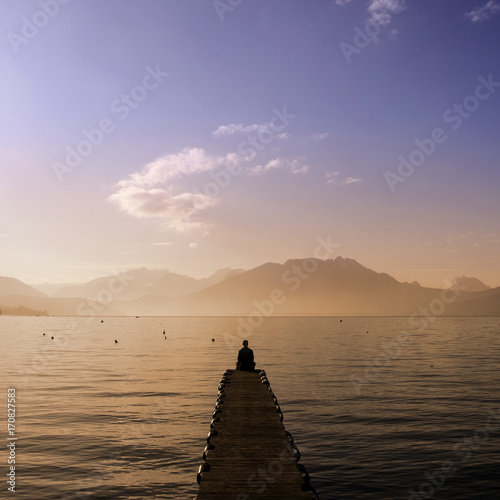 Man sitting on Annecy lake pontoon © fullempty