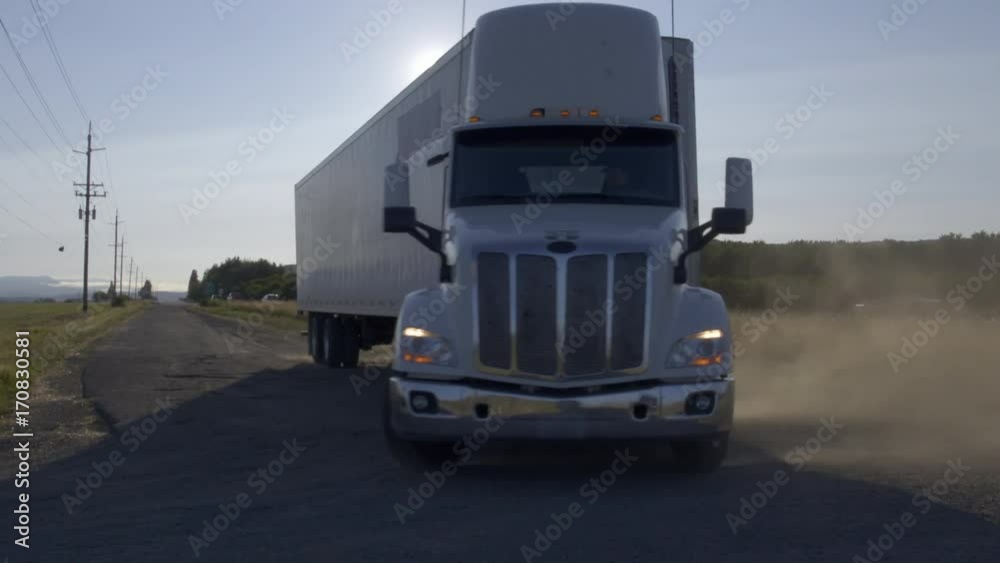 Large truck making a turn towards camera on a country road, kicking up lots of dust and dirt. Hand-held, real-time 4K. Large truck making a turn towards camera on a country road, kicking up lots of dust and dirt. Hand-held, real-time 4K.