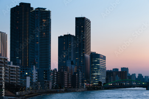夕暮れの勝ちどき橋と隅田川沿いのビル群、東京
