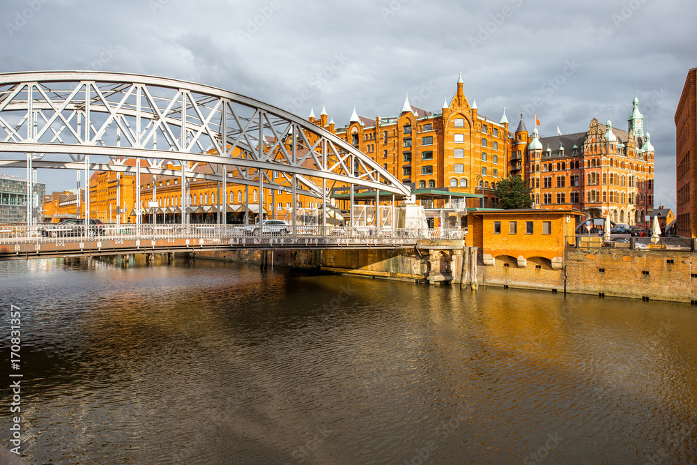 Naklejka premium View on the old warehouses and iron bridge in Hafen district of Hamburg city during the sunset in Germany