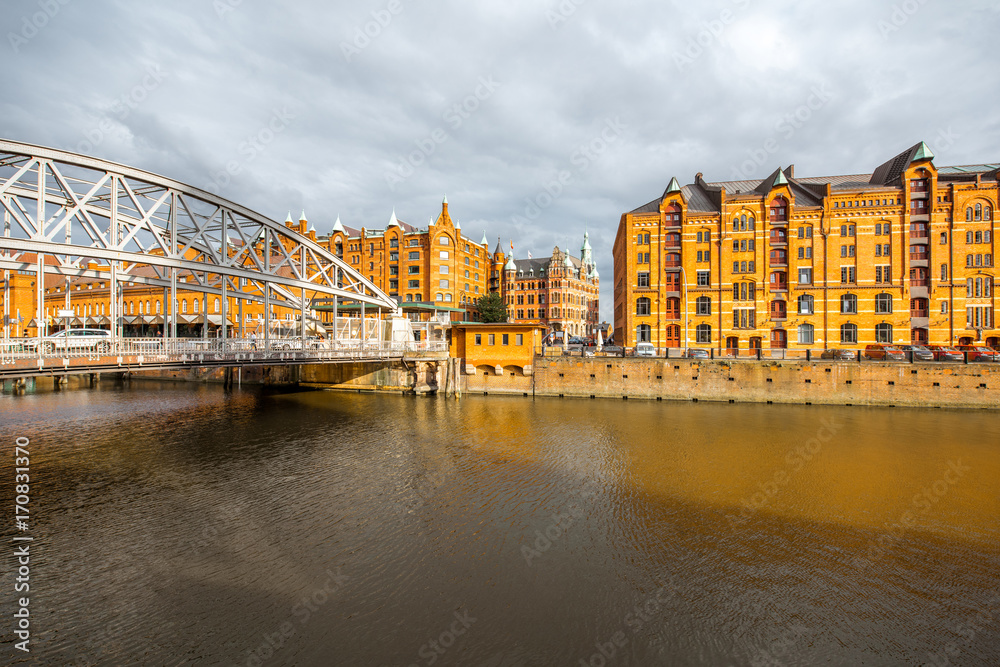 Naklejka premium View on the old warehouses and iron bridge in Hafen district of Hamburg city during the sunset in Germany