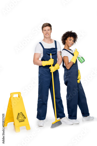 smiling multiethnic cleaners with cleaning supplies