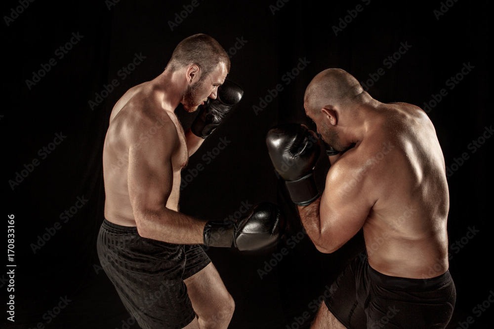 Two muscular men fighting, bodybuilders punching each other, training in martial arts, boxing, jiu jitsu
