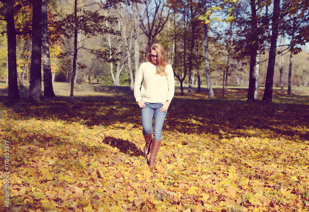 Happy young woman in park on sunny autumn day Happy young woman in park on sunny autumn day