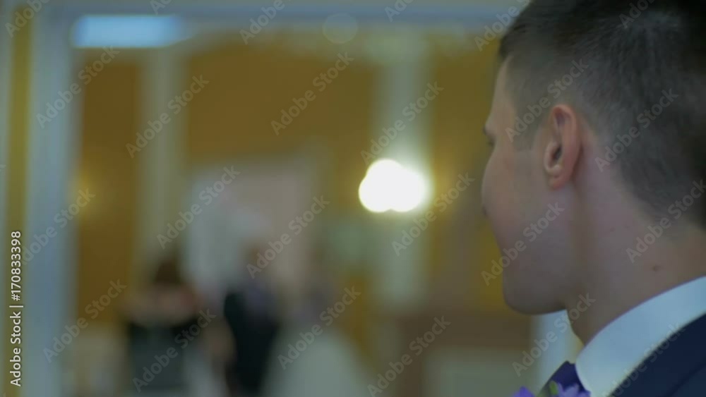 Groom looks at the bride and smiles close up Groom looks at the bride and smiles close up